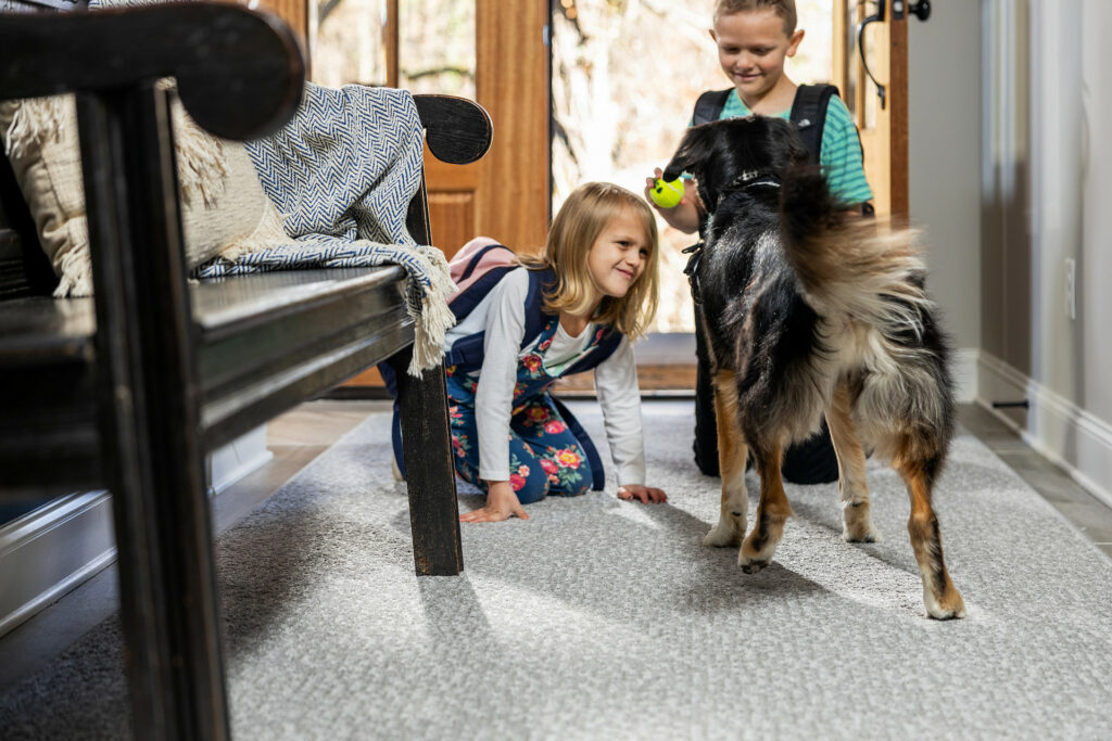Kids plying with dog on carpet flooring | Leaf Floor Covering